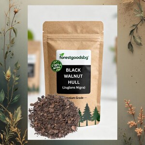 Può includere: Un sacchetto di carta marrone etichettato forestgoodsbg Black Walnut Hull (Juglans Nigra) con un sigillo 100% naturale. Un mucchio di pezzi di guscio di noce nera, marrone scuro, grossolani e granulari, si trova davanti al sacchetto con pini.