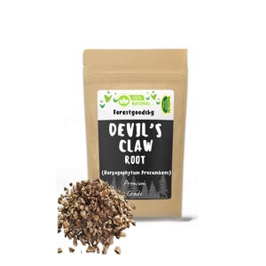 Op de afbeelding: Een bruine papieren zak met de tekst "DEVIL'S CLAW ROOT", de tekst "forestgoodsbg" en "100% NATURAL". Een stapel gedroogde, gehakte wortelstukken ligt voor de zak. Het product is "Premium Grade".