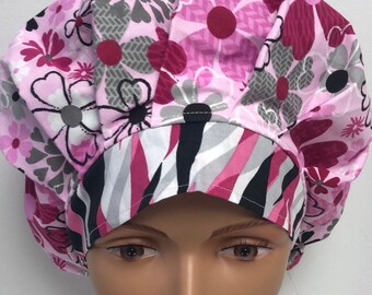 May include: A pink and black patterned surgical scrub hat with a zebra print on the underside. The hat is made of soft, comfortable fabric and is designed to be worn by medical professionals.