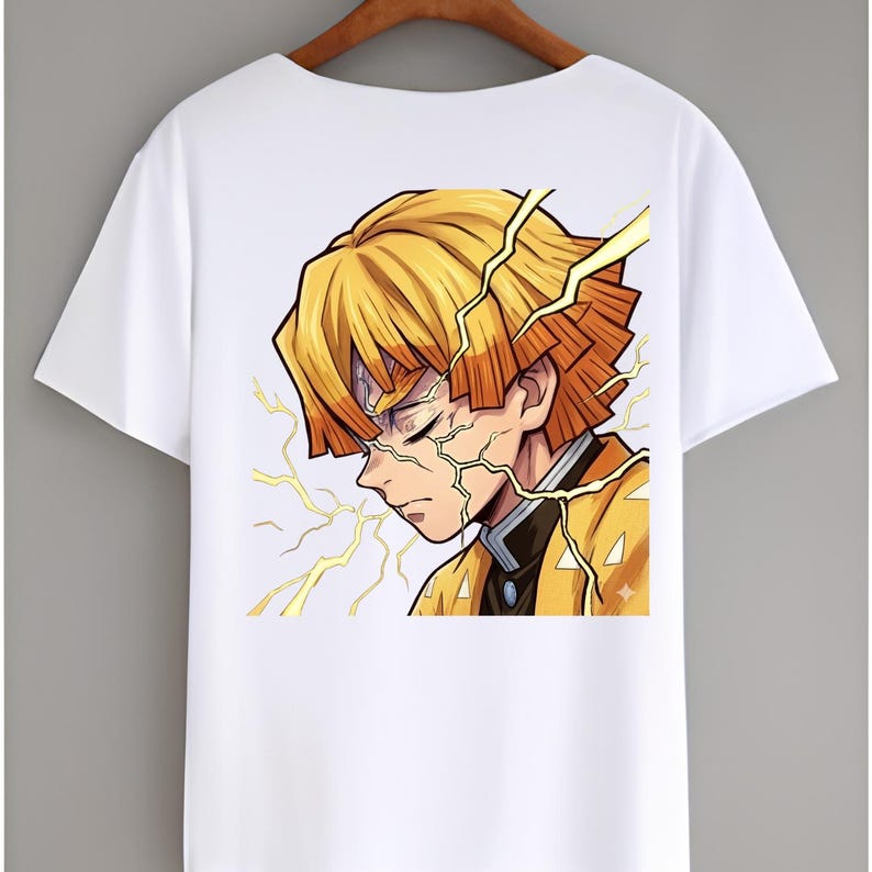 May include: A white short-sleeved t-shirt featuring a graphic print of an anime character with short yellow hair and orange tips. The character has closed eyes and is surrounded by yellow lightning bolt illustrations on a white background.