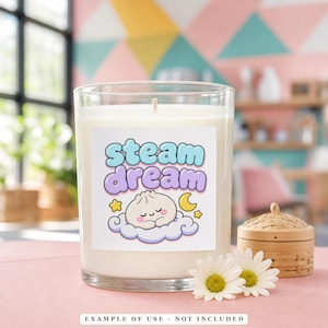 A clear candle in a glass jar with a label featuring a sleeping dumpling on a cloud, with the text "STEAM dream" above it.