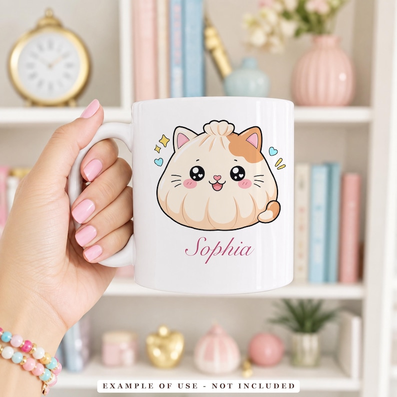 A hand holding a white mug with a cartoon illustration of a smiling dumpling with cat ears and the name "Sophia" written below it.