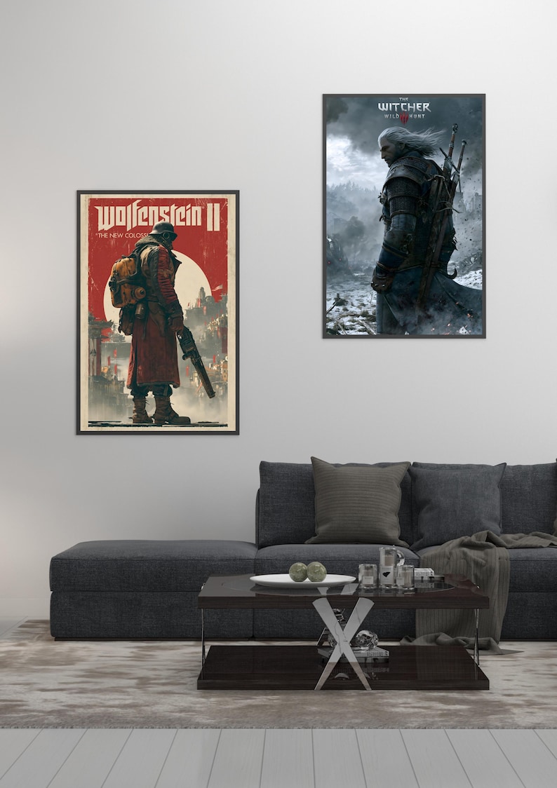 Peut inclure: Deux affiches encadr&eacute;es sur un mur blanc. L'affiche de gauche est pour "Wolfenstein II" avec une figure en manteau rouge. L'affiche de droite est pour "The Witcher 3: Wild Hunt" avec un personnage en armure. Un canap&eacute; gris fonc&eacute; et une table basse sont devant.