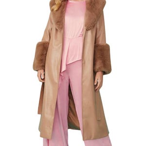 May include: A tan long coat with a wide faux fur collar and matching faux fur cuffs, worn over a light pink sleeveless top with an asymmetrical peplum hem and matching wide-leg trousers. The text BLACKFORGE is visible in the top left corner.