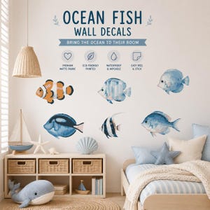 Può includere: Adesivi murali con pesci dell'oceano che presentano varie illustrazioni di pesci in stile acquerello nei toni dell'arancione, blu e bianco. Il testo recita OCEAN FISH WALL DECALS, BRING THE OCEAN TO THEIR ROOM, PREMIUM MATTE FABRIC, ECO-FRIENDLY PRINTED, WATERPROOF & WIPEABLE, EASY PEEL & STICK.