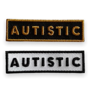 Op de afbeelding: Twee geborduurde patches met het woord "AUTISTIC" in zwarte letters. De bovenste patch heeft een zwarte achtergrond met gouden stiksels. De onderste patch heeft een witte achtergrond met zwarte stiksels.