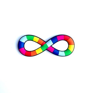 May include: A colorful infinity symbol with a rainbow pattern. The symbol is composed of various rectangular segments in shades of red, orange, yellow, green, blue, and purple, outlined in black. The object is set against a white background.