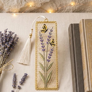 Könnte beinhalten: Ein rechteckiges Lesezeichen aus Metall mit einem goldfarbenen Rahmen und einem feinen Drahtgitter in der Mitte. Das Design zeigt eine vertikale Lavendelpflanze mit violetten Blüten und grünen Blättern, akzentuiert durch zwei gelb-schwarze Schmetterlinge.