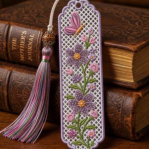 Può includere: Un segnalibro rettangolare con un motivo a griglia bianco ricamato con fiori viola, steli verdi e una farfalla rosa. Il segnalibro è bordato con filo color lavanda e include una perlina di legno decorativa e una nappa in seta multicolore.