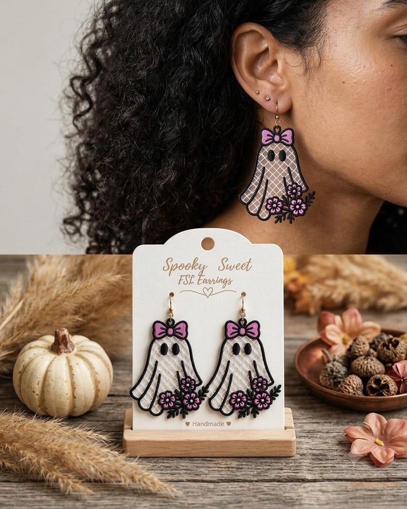 May include: A pair of dangling earrings featuring a white ghost design with a pink bow and purple flowers. The ghost has a black outline and a cross-hatched texture. The display card reads Spooky Sweet FSL Earrings and Handmade.