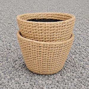 May include: A pair of stacked, round, tan-colored woven planters with a textured, basket-like exterior. The planters feature a wide, open top rim and a deep, hollow interior with a dark, solid-colored base visible inside the upper container.
