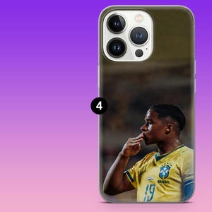 May include: A smartphone case featuring a photographic print of a soccer player wearing a yellow jersey with the Brazil national team crest and the number 19. The player is shown in profile, kissing their hand. The case has a triple-lens camera cutout.