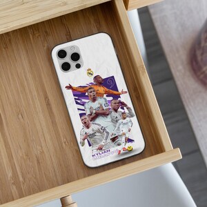 K&ouml;nnte beinhalten: Eine wei&szlig;e Smartphone-H&uuml;lle mit einer Collage von Kylian Mbapp&eacute; in Real Madrid Fu&szlig;balltrikots. Das Design zeigt den Spieler in verschiedenen Posen, die Nummer 9, das Real Madrid Wappen und den Text KYLIAN MBAPP&Eacute; am unteren Rand der H&uuml;lle.