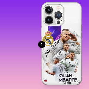 K&ouml;nnte beinhalten: Eine wei&szlig;e Smartphone-H&uuml;lle mit einer grafischen Collage des Fu&szlig;ballers Kylian Mbapp&eacute; im Trikot von Real Madrid. Das Design enth&auml;lt das Real Madrid-Wappen, den Text Kylian Mbapp&eacute; und das Wort Hat-Trick auf wei&szlig;em Hintergrund.