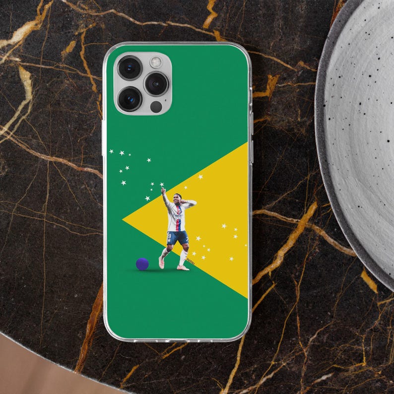 May include: A clear phone case featuring a green background with a large yellow triangle and small white stars. A soccer player in a white and blue uniform is depicted in a celebratory pose next to a small purple ball on the lower left side.