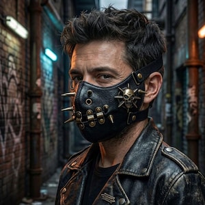 May include: A black leather face mask featuring metallic gold-toned spikes, circular studs, and a prominent skull emblem on the side. The mask is secured with adjustable black straps and is worn over the lower face, paired with a black leather jacket.