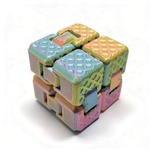 Könnte beinhalten: Ein irisierendes Infinity-Cube-Fidget-Spielzeug mit einem mehrfarbigen Farbverlauf in Pastellrosa, Blau und Gelb. Die Oberfläche jedes verbundenen Blocks zeigt ein texturiertes Rautenmuster mit sichtbaren 3D-Druck-Schichtlinien.