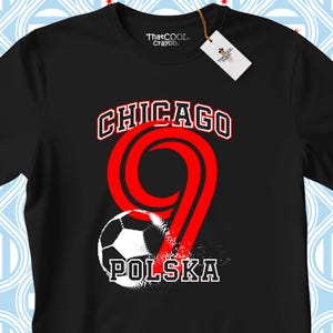 May include: A black short-sleeved t-shirt featuring a graphic print with the text CHICAGO at the top and POLSKA at the bottom. A large red number nine is centred with a black and white football graphic integrated into the design.