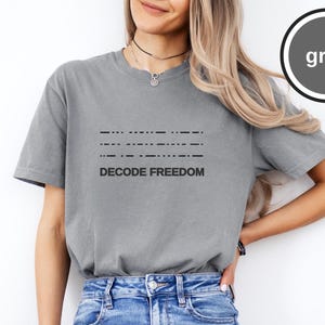Camiseta con el diseño "Decode Freedom" en código Morse, camiseta gráfica minimalista vintage.
