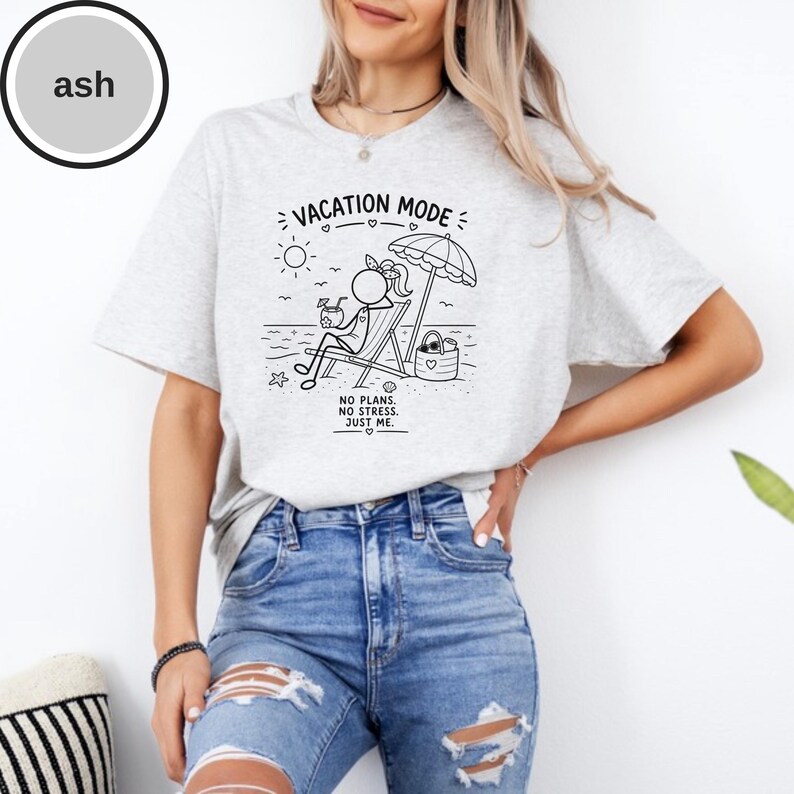 May include: Ash-colored t-shirt with a black graphic of a stick figure relaxing on a beach chair under an umbrella. The text reads "VACATION MODE" and "NO PLANS. NO STRESS. JUST ME."