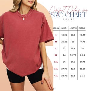 May include: A red short-sleeve t-shirt alongside a size chart titled Comfort Colors 1717. The chart displays sizes from S to 4XL, detailing width, length, and sleeve measurements in inches to assist with selecting the appropriate garment size for the wearer.