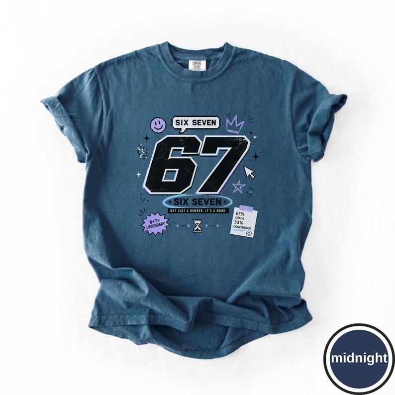 Pu&ograve; includere: Una t-shirt a maniche corte blu scuro con una grande grafica nera del numero 67 e la scritta SIX SEVEN. Altri elementi grafici includono una faccina sorridente, una corona, un cursore, stelle, una clessidra e un foglietto con 67 CHAOS 33% CONFIDENCE.