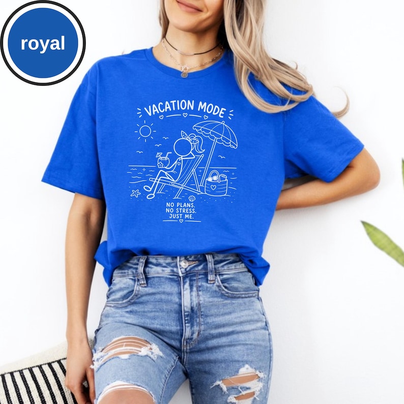 May include: Royal blue t-shirt with a white graphic that reads "VACATION MODE" and features a stick figure relaxing on a beach chair under an umbrella. The text "NO PLANS. NO STRESS. JUST ME." is also included. The shirt is made of a soft material.