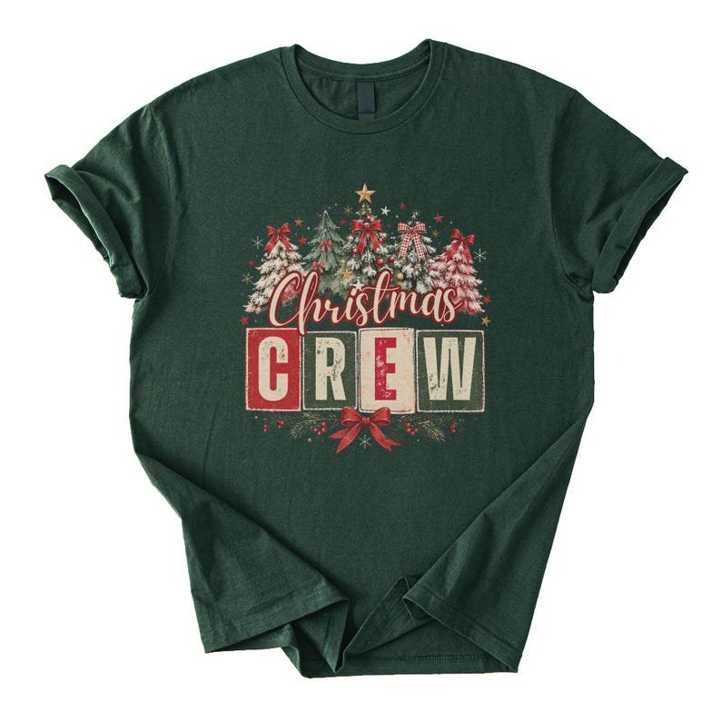 Op de afbeelding: Een donkergroen T-shirt met korte mouwen en een grafische print van vijf versierde kerstbomen met rode strikken en sterren. Onder de bomen staat de tekst "Christmas CREW" in een gestileerd lettertype, met het woord CREW in vier blokken.
