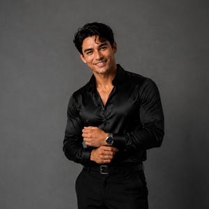May include: A black long-sleeved button-down shirt with a subtle sheen, paired with black trousers, a black belt, and a silver wristwatch. The shirt features a classic collar and buttoned cuffs, while the trousers are tailored with a straight-leg cut.