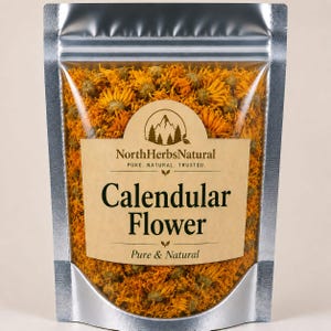 Puede incluir: Una bolsa transparente con bordes plateados llena de flores de caléndula secas. La bolsa tiene una etiqueta beige con el texto "North Herbs Natural" y "Calendular Flower". Las flores son naranjas y amarillas.