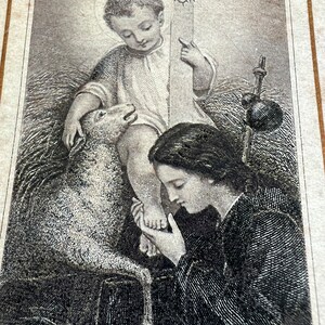 May include: A black and white engraving of a woman kneeling and touching the foot of a young boy holding a cross. The boy is sitting on a bed of straw and a lamb is beside him.