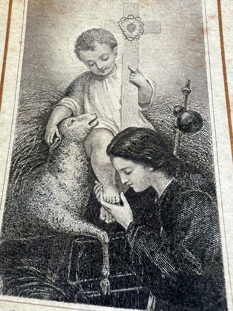 May include: A black and white engraving of a woman kneeling and touching the foot of a young boy holding a cross. The boy is sitting on a bed of straw and a lamb is beside him.