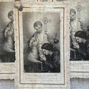 May include: A vintage religious card with a black and white illustration of a young boy with a lamb. The text on the card reads "J'ai rachet&eacute; le monde par les att de la Greche".
