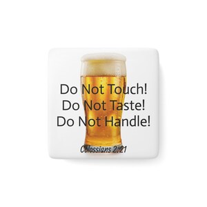 May include: A square, white product features a tall glass of beer with a foamy head. The text "Do Not Touch! Do Not Taste! Do Not Handle!" is printed in black, along with "Colossians 2:21".
