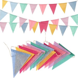 Peut inclure: Un ensemble de fanions triangulaires en tissu texturé aux teintes pastel jaune, bleu, vert, rose et rouge. Les fanions sont disposés en deux rangées horizontales et en un groupe empilé, tous fixés sur une fine ficelle de couleur naturelle.