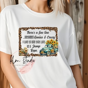 May include: White t-shirt with a graphic of a blue pickup truck with sunflowers and a leopard print background. The text reads "There's a fine line...Between Genius & Crazy. I like to use that line as a jump rope."