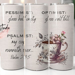 Op de afbeelding: Drie roestvrijstalen bekers met een wit canvas-achtig ontwerp. De linker beker heeft de tekst "PESSIMIST: glass half empty" en "PSALM ST: "my cup runneth ever... Psalm 2.3.5". De rechter beker heeft de tekst "OPTIMIST: glass half full" en heeft een bloemmotief met een theekopje en een schoteltje.