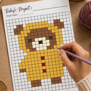 May include: A white grid paper sheet featuring a pixel art bear design in yellow and brown with three red squares on the torso. The top of the page includes the text Today's Project: and Start Date: with lines for writing. The grid has numbered axes.