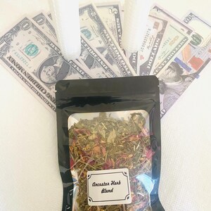 May include: A black pouch with a clear window displaying a blend of dried herbs and flowers, labeled "Ancestor Herb Blend." Two white candles and several US dollar bills are arranged behind the pouch.