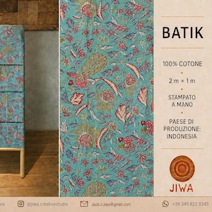 May include: A piece of turquoise fabric with a red and green floral and peacock pattern. The text on the right reads BATIK, 100% COTTON, 2 m x 1 m, HAND-PRINTED, COUNTRY OF ORIGIN: INDONESIA, and JIWA. The fabric is displayed on a wooden rack.