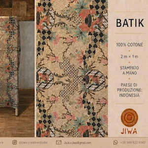 Op de afbeelding: Een rechthoekig stuk beige stof met een veelkleurig bloemen- en geometrisch batikpatroon. De tekst vermeldt 100% katoen, 2m x 1m, handbedrukt en land van herkomst: Indonesië. De merknaam Jiwa staat onder een rond houten icoon.