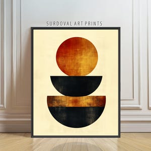 May include: Abstract art print featuring a black frame. The artwork displays a large, textured, orange-red circle above two black semi-circular shapes, with a smaller orange-brown band between them. The background is a light beige color. The text "SURDOVAL ART PRINTS" is at the top.