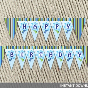 May include: Printable blue and green birthday banner with the words "Happy Birthday" in white letters. The banner features a blue and green striped background with a white cloud and a blue scuba diver on each flag.