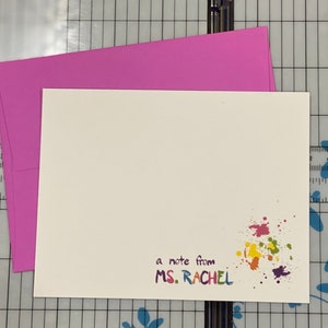 May include: A white card with a colorful paint splatter design and the text "a note from MS. RACHEL".