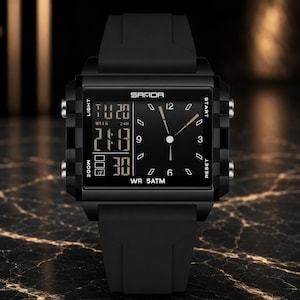 May include: A black digital and analog wristwatch with a square case and silicone strap. The face features the brand name SAMOA, a digital display showing the date and time, and an analog clock with white hands. The watch is marked WR 5ATM.