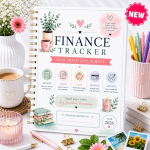 Pode incluir: Um planejador financeiro de espiral com capa branca, ilustrado com uma planta em vaso, uma caneca rosa e livros. O texto diz FINANCE TRACKER, PLAN. TRACK. SAVE. ACHIEVE., incluindo seções para orçamento, rastreamento, poupança e metas.