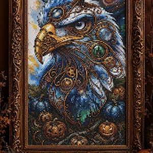Puede incluir: Un cuadro de pintura de diamantes que muestra una cabeza de águila estilizada con intrincados patrones azules, dorados y verdes, sobre un fondo de galaxia arremolinada y pequeñas calabazas naranjas, en un marco dorado de estilo antiguo.