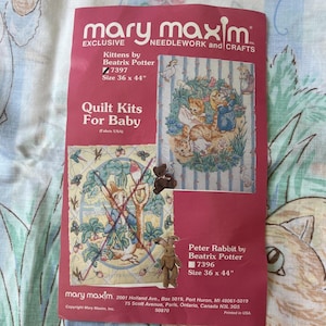 May include: A magenta Mary Maxim quilt kit instruction sheet featuring Beatrix Potter illustrations. It displays two designs: Kittens and Peter Rabbit, both sized 36 x 44 inches. The sheet includes text, product numbers 7397 and 7396, and company details.