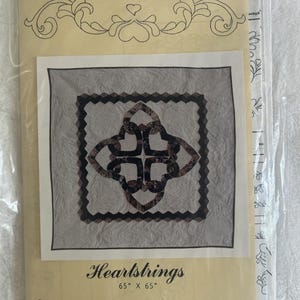 May include: A quilt pattern packet titled Heartstrings by Virginia Robertson from Osage County Quilt Factory. The cover features a 65" x 65" quilt design with interlocking heart shapes in dark patterned fabric against a light gray background.