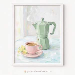 May include: A framed painting featuring a light green moka pot and a light pink teacup filled with coffee on a saucer. A small cluster of yellow flowers sits beside the cup. The text "painted mushroom co" appears at the bottom of the image.